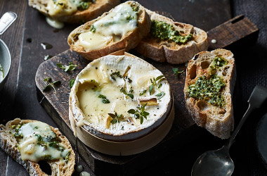 Baked smoked garlic cheese with pesto toasts