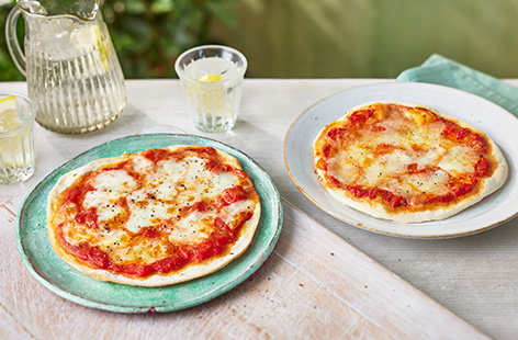 Kids will love making these easy pizzas. They use a packet of pizza base mix and are topped with plum tomatoes and torn mozzarella for an easy snack or dinner.