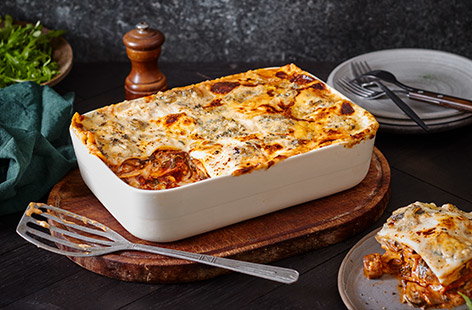 This easy cheesy lasagne is layered with a rich tomato, mushroom and spinach sauce and dotted with ricotta then topped with blue cheese for an indulgent dinner party main.