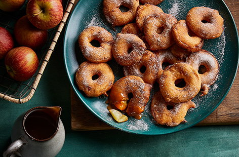 Autumnal apples make for a perfect, rustic dessert like these spiced doughnuts with a runny caramel sauce