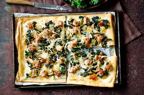 These sausage and kale pizzas are topped with three types of creamy cheese and golden, crispy sausage