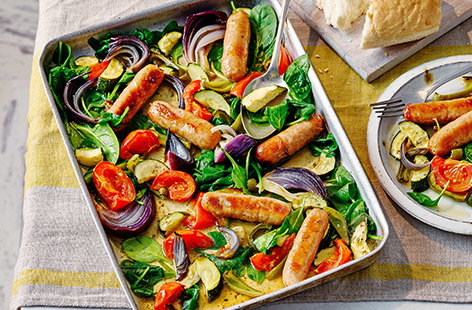 Give your midweek traybake a summer makeover with a light, seasonal veg mixture and juicy pork sausages