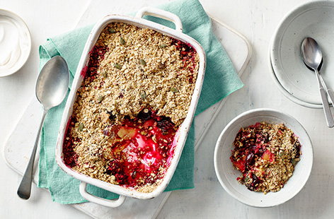 Warm and comforting, this classic crumble recipe is super easy to make. Apples, cherries and blackberries are topped with an oat and seed crumble topping, then baked until golden. Serve with natural yogurt and dig in!