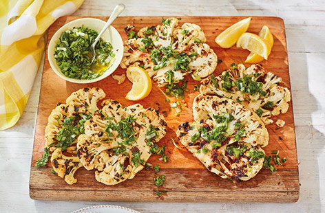 BBQ season doesn’t have to just be about meat as these smoky charred cauliflower steaks show. A simple vegan BBQ idea, the steaks are brushed with an aromatic caraway and garlic oil before being grilled and served with a punchy fresh herb dressing.