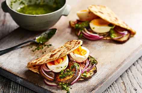 Zhoug is a vibrant green sauce made using coriander, garlic, mint and cumin, like a spicy Middle Eastern pesto. Here it is paired with chopped boiled eggs and crispy fried aubergines to fill a delicious pitta