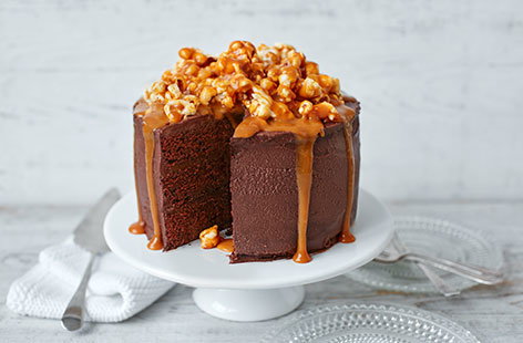 Whatever the occasion, celebrate in style with this showstopper of a cake! Layers of light chocolate sponge sandwiched with a dark chocolate ganache, all encased in a mascarpone icing and topped with a caramel drizzle and gooey salted caramel popcorn