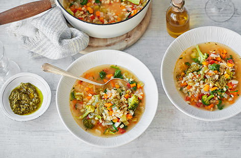 You really can't beat a bowl of steaming veg-packed soup – this hearty supper is crammed with carrots, celery, tomatoes and spinach, and topped with a dollop of pesto for a zesty finish.